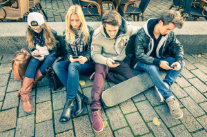 Group of young hipster friends playing with smartphone